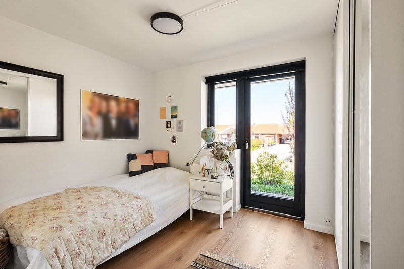 Zimmer mit Einzelbett und Tür zum Garten
