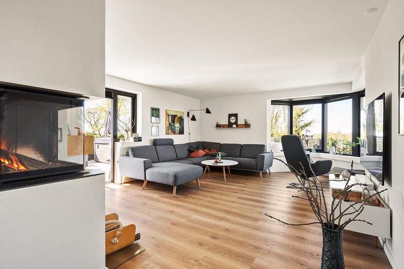 Wohnzimmer mit Sofa, Kaminofen und Erker